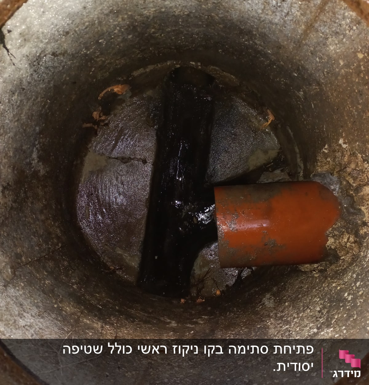 צינור כתום בתוך צינור בטון עם לכלוך